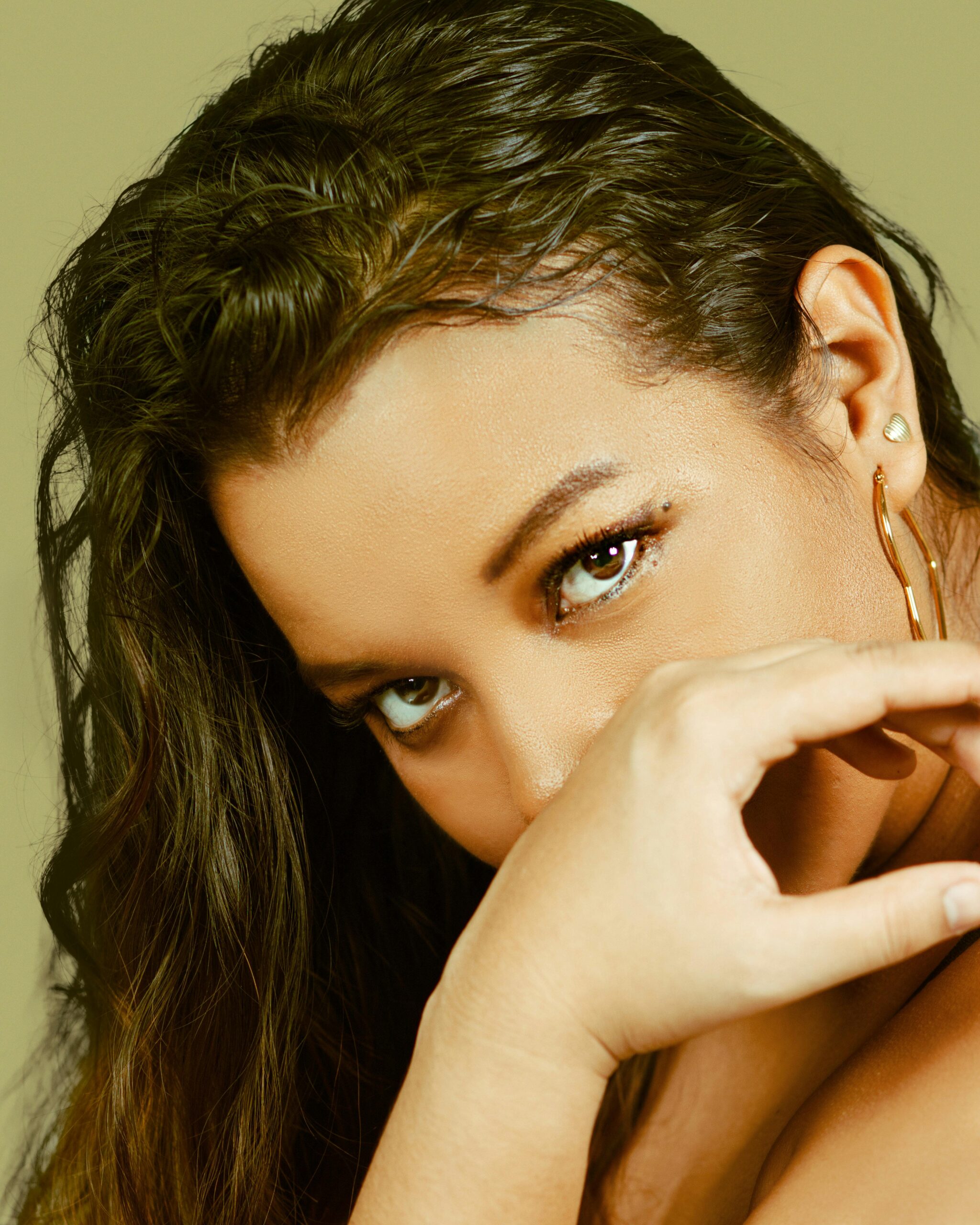 Elegant artistic portrait of a woman with striking gaze and soft lighting.
